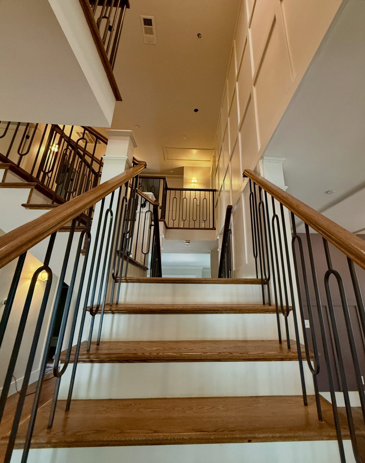 Wood staircase with iron railing and lighting